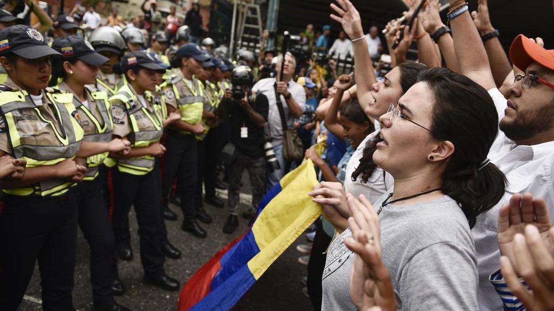 Protesters in Caracas shout at police officers during a demonstration against President Maduro on Wednesday.