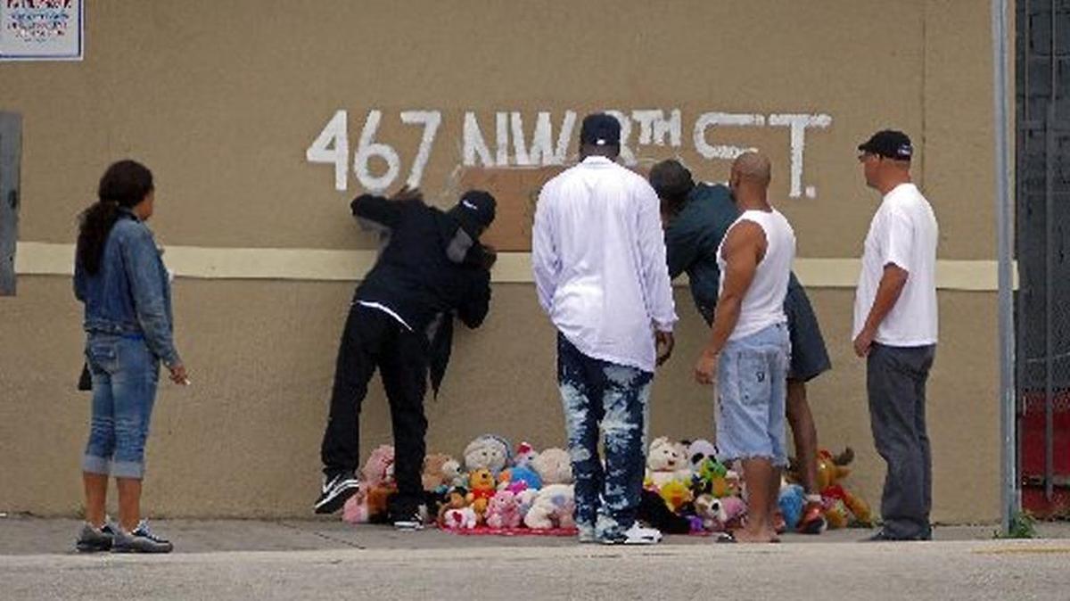 Mourners at a memorial after a Christmas Day shooting in 2014. One man was killed, two others injured.