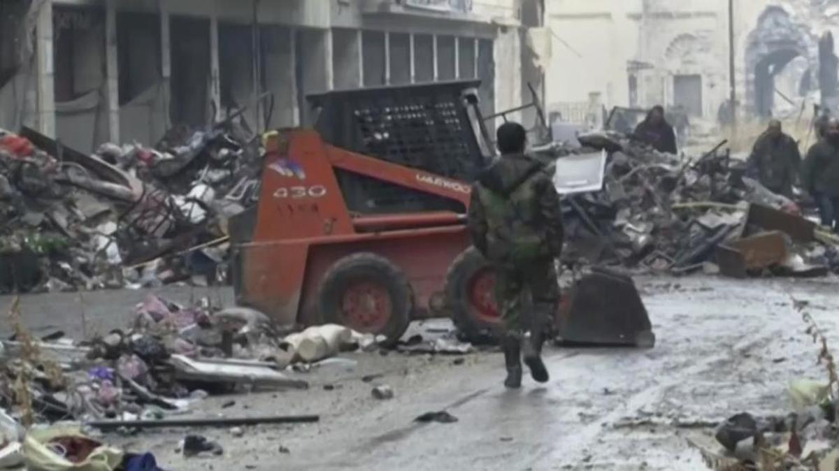 Syrian soldiers walk among damaged buildings on a street filled with debris in Aleppo, Syria. A cease-fire between rebels and the Syrian government collapsed on Wednesday.