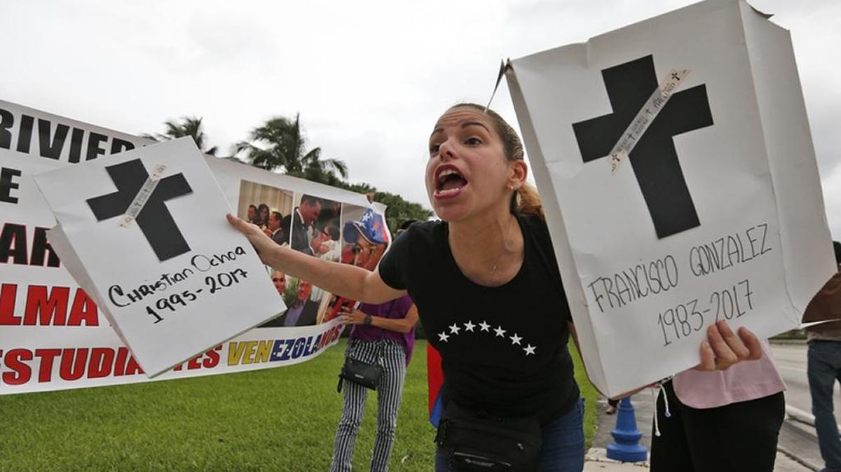 In May, Jenny Avila, in Doral, holds names of people who have died amid protests in Venezuela.