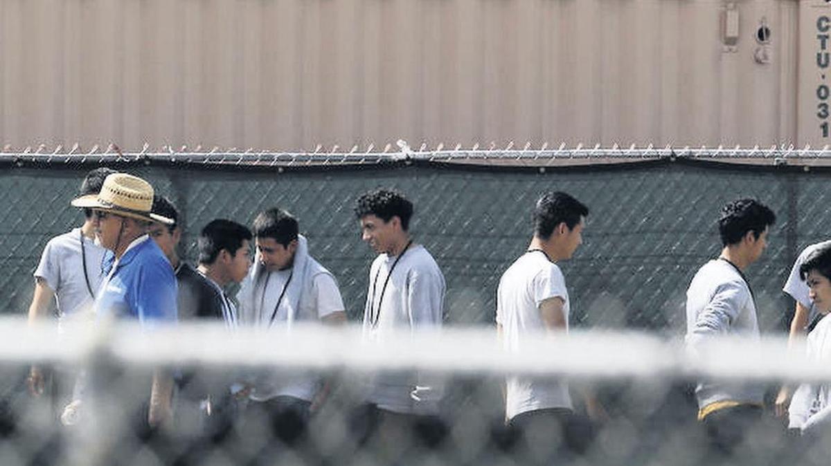 Migrant youths walk outside at the Homestead Temporary Shelter for Unaccompanied Children, a former Job Corps site that now houses them.