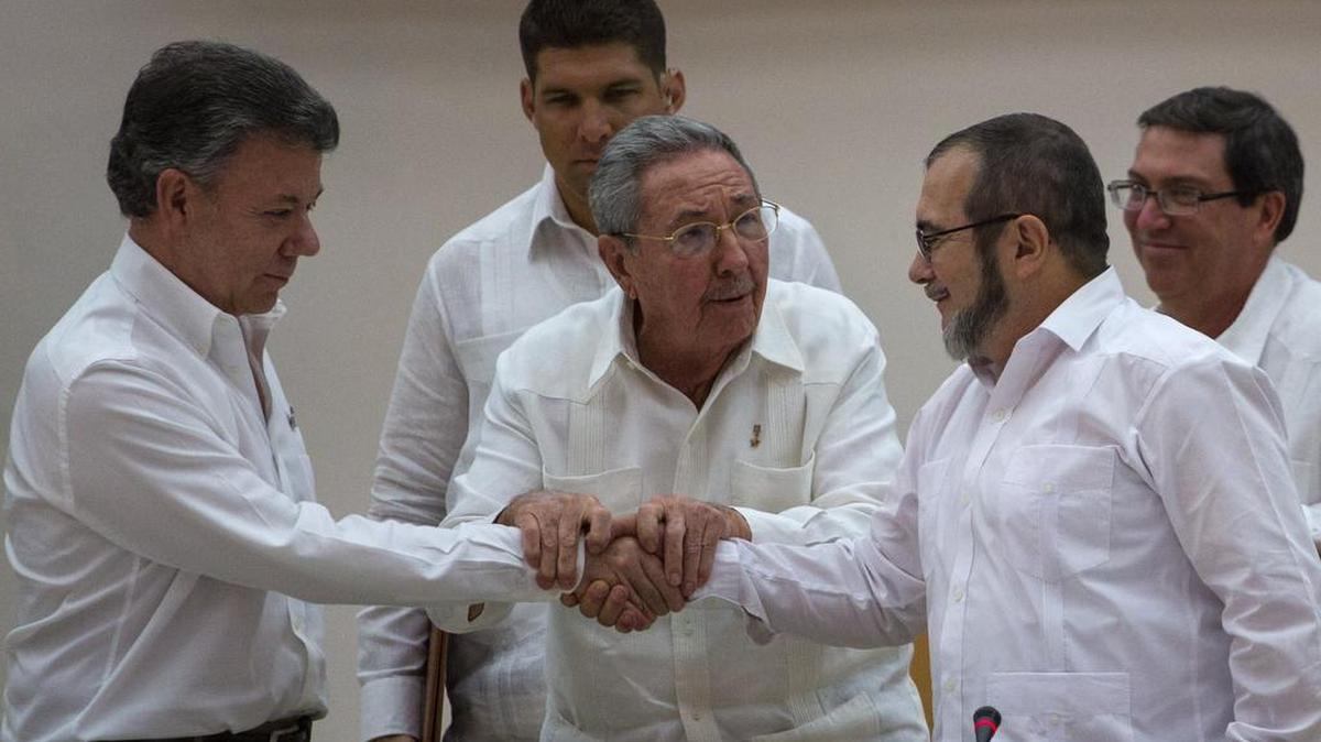 President Juan Manuel Santos, left, shakes hands with FARC rebel commander Timoleon Jimenez, right, in September. Cuban President Raúl Castro, whose country hosted peace talks, is at the center.