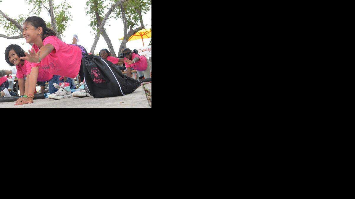 
Alana Powell, right, and Cing Huai practice the extended cat pose during a session led by Yoga Gangsters at Virginia Key Beach Park in 2013. 
