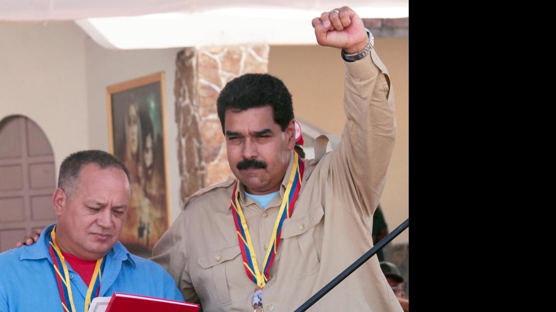 
POWER COUPLE: Venezuelan President Nicolas Maduro raises his arm as he stands with National Assembly President Diosdado Cabello. 
