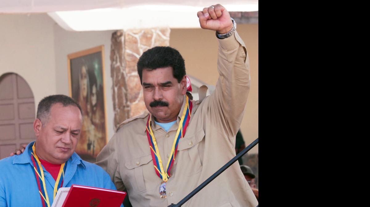 
POWER COUPLE: Venezuelan President Nicolas Maduro raises his arm as he stands with National Assembly President Diosdado Cabello. 
