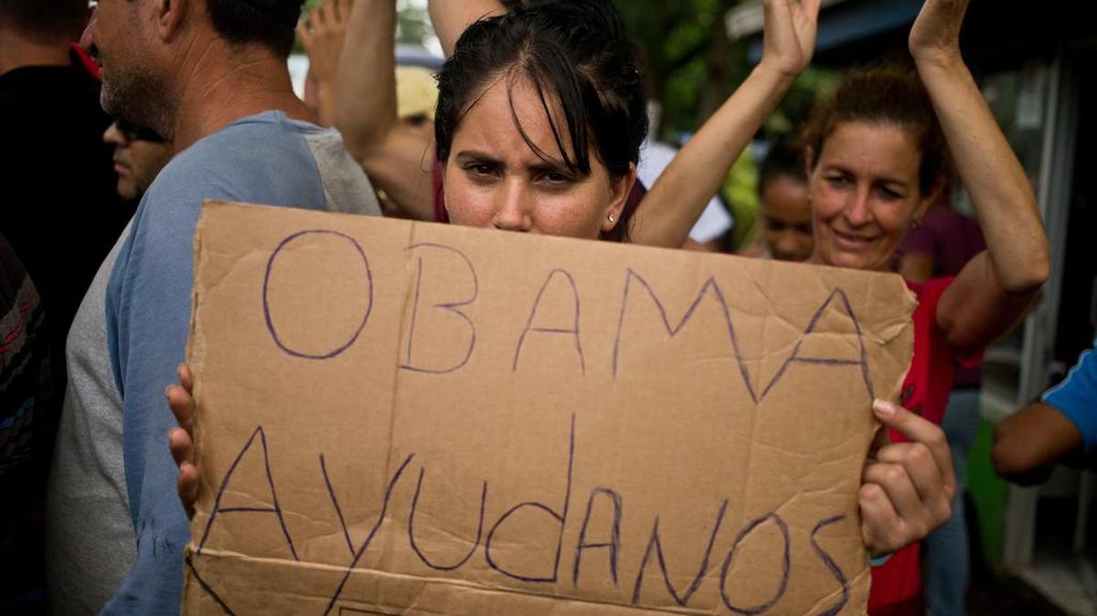 A Cuban migrant holds a sign that reads in Spanish “Help us Obama” during a protest in Costa Rica last week.