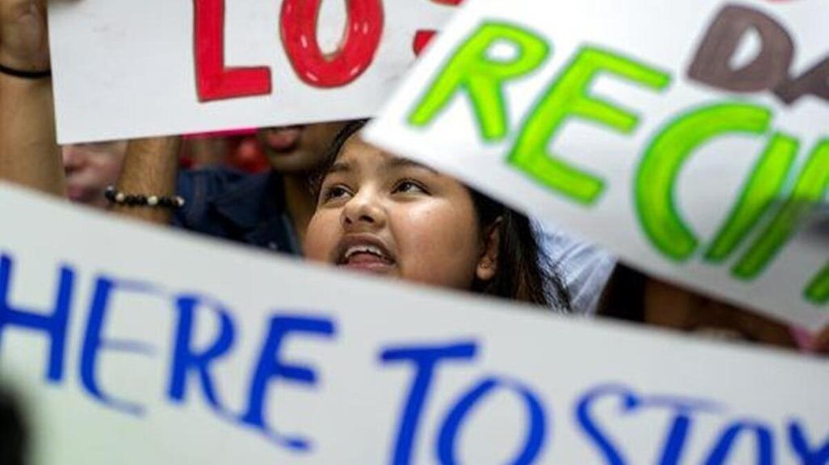 A young woman stands with others in support of Deferred Action for Childhood Arrivals — DACA — at an August rally near Trump Tower in New York.