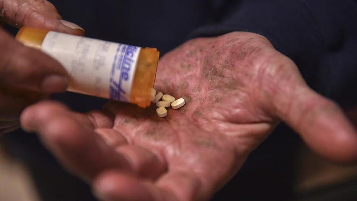A man in Mount Airy, Maryland shakes Suboxone pills from a bottle.
