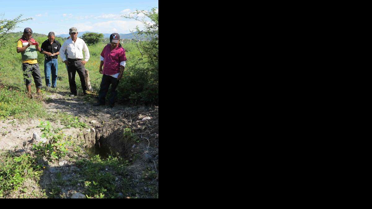 
SIGNS OF VIOLENCE: Civilian community police in Mexico look at an excavated grave site near Iguala that is among a cluster of similar sites found recently.
