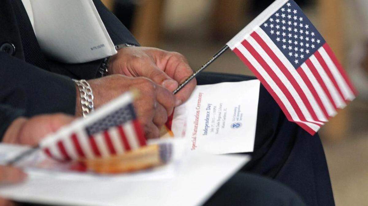 Carlos Lopez holds the American flag during a swearing-in ceremony at North Dade Regional Library in 2015.