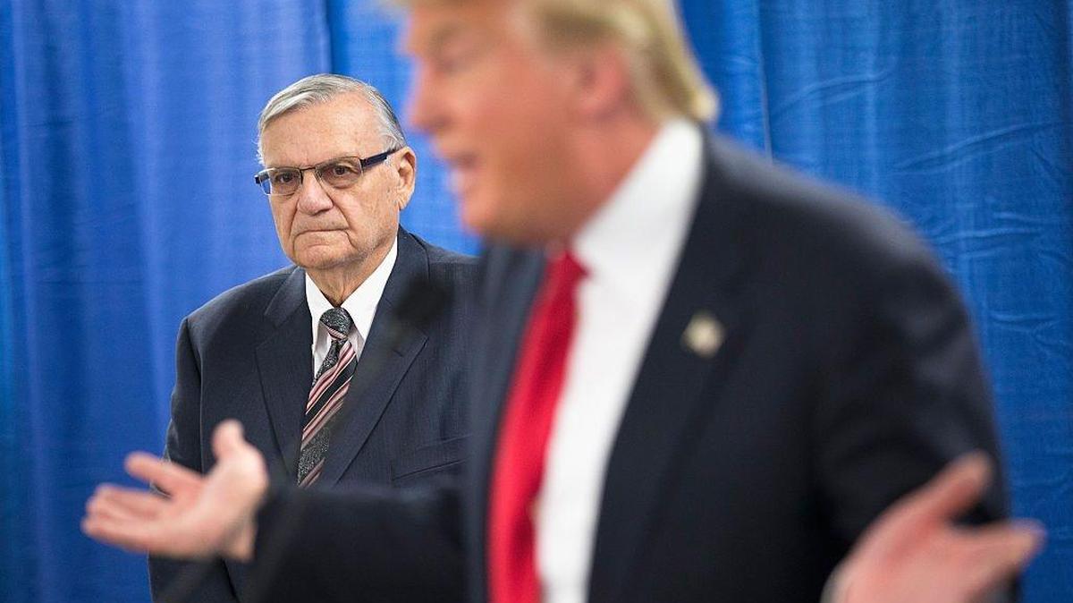 In 2016, Sheriff Joe Arpaio listened as presidential candidate Donald Trump spoke to the press before a rally in Iowa.