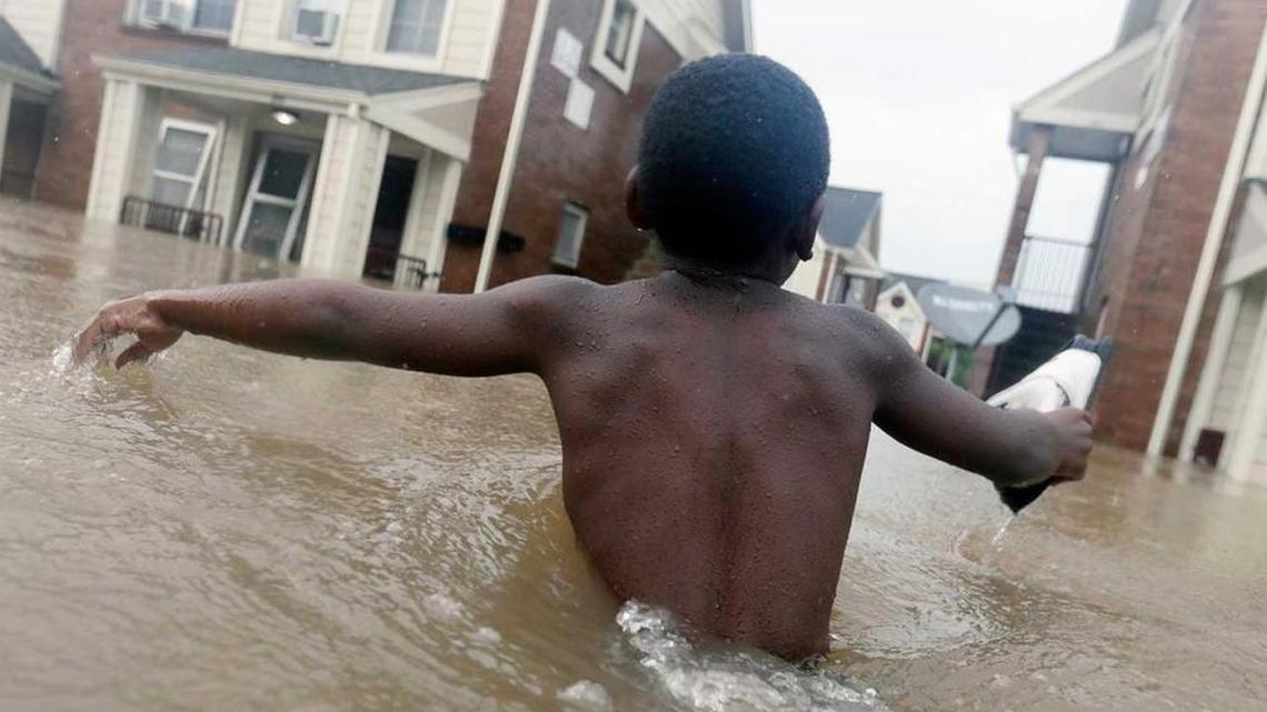 Jayveon Murphy, 10, makes is way through floodwaters from Hurricane Harvey to check on a neighbor at a Houston apartment complex.