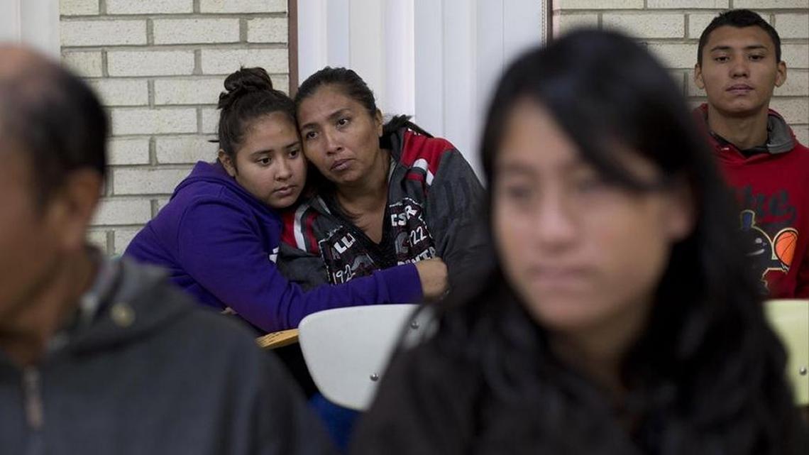 Central American migrants embrace as they wait for assistance in January at a center for newly arrived migrant families with children in McAllen, Texas.