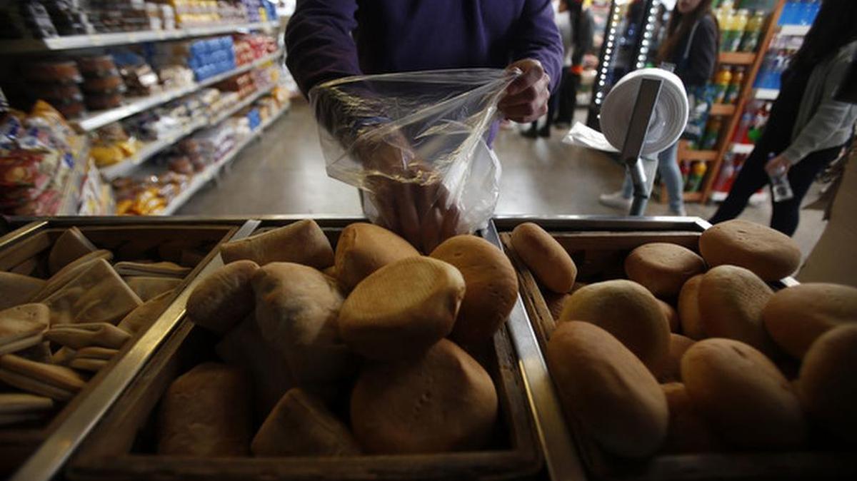 A man buys bread at a Wal-Mart Ekono convenience store in Santiago, Chile.