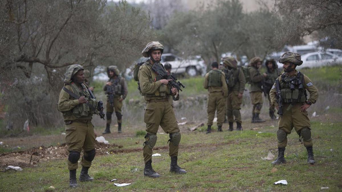 Israeli soldiers patrol the area where a Palestinian teenager was shot and killed when he tried to stab a soldier in the village of Beita.