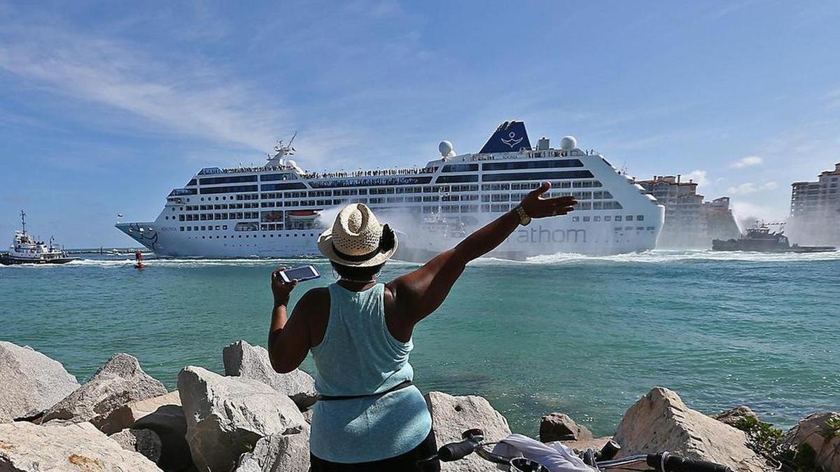 A Cuban woman waves at the Adonia as it leaves PortMiami in 2016, en route to Cuba.