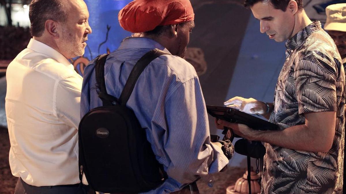 Ronald Book, chairman of the Homeless Trust, left, watches as Manuel Sarria inputs data on his tablet about a homeless person during a survey in downtown Miami last month.