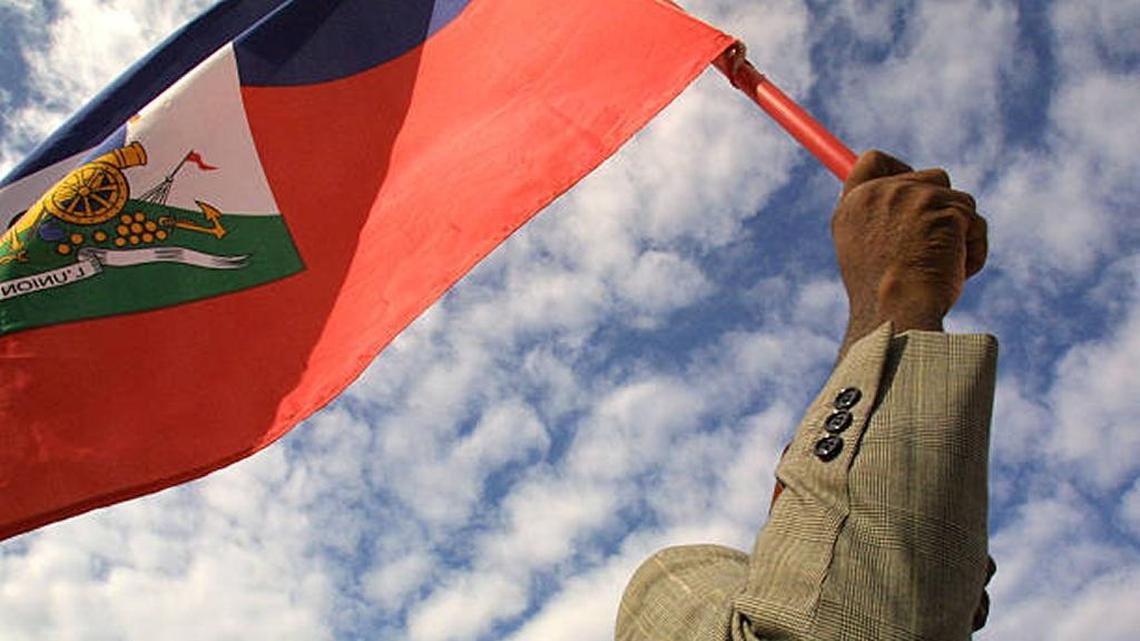 A man holds a Haitian flag as Haitian Americans from throughout Miami-Dade and Broward Counties hold a demonstration for democracy in 2001.