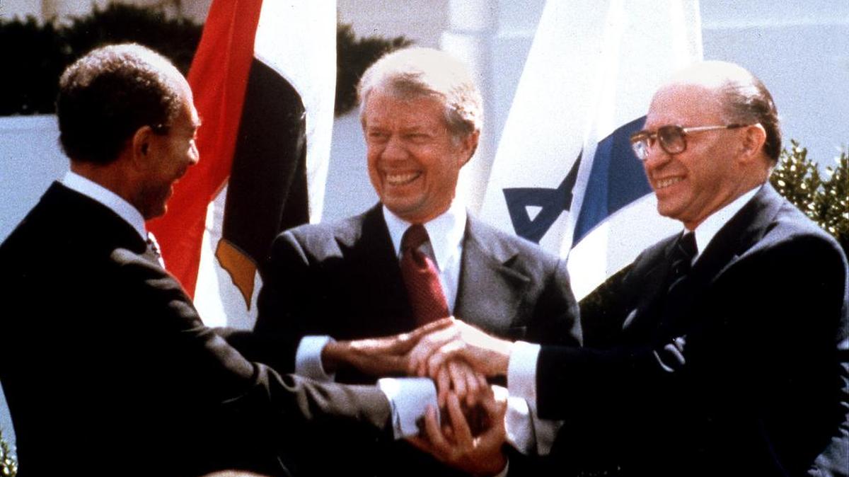 Egyptian President Anwar Sadat, U.S. President Jimmy Carter, and Israeli Prime Minister Menachem Begin clasp hands on the north lawn of the White House March 26, 1979, as they completed signing of the peace treaty between Egypt and Israel. Such examples of successful peace initiaves between Arabs and Israelis are all too few.
