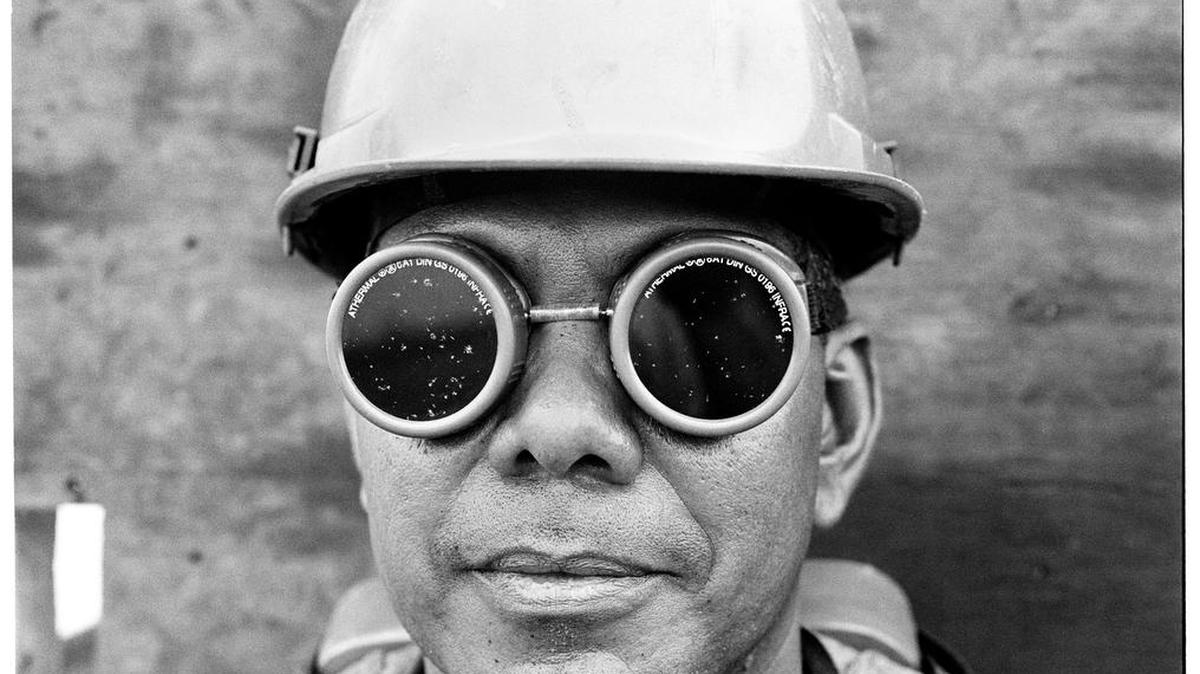 A portrait of a welder working the expansion of the Panama Canal.