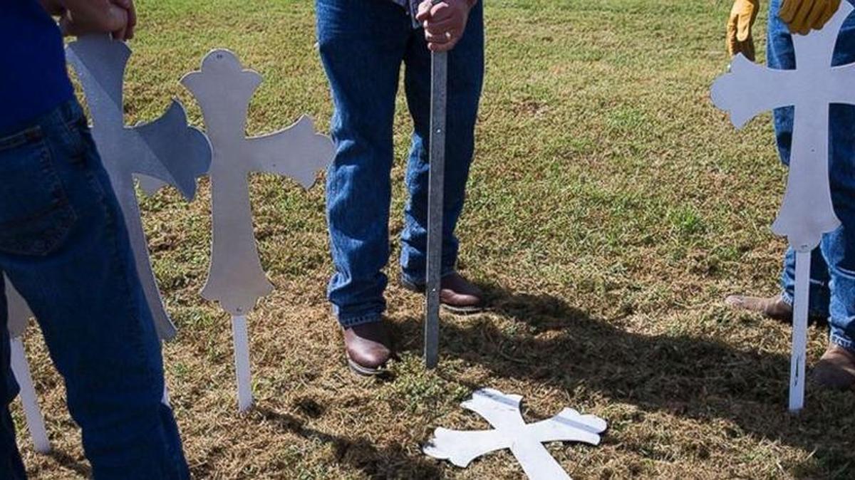 People place crosses to honor victims of Sunday’s massacre at a church in Sutherland Springs, Texas.