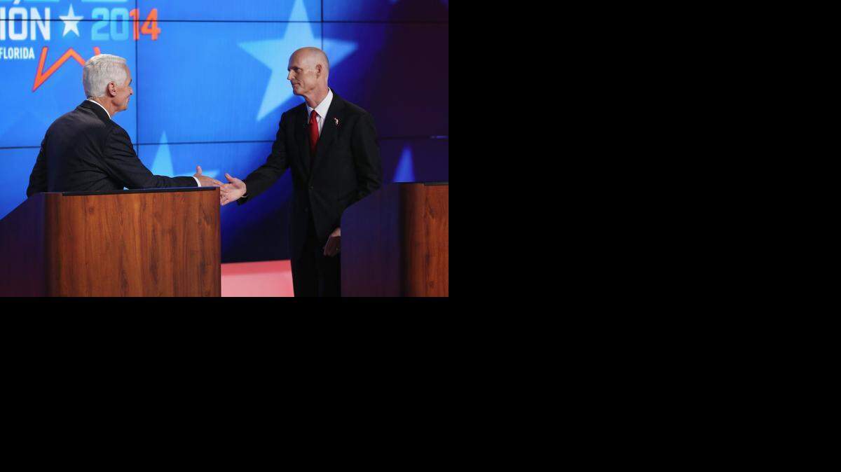 
ON OPPOSITE SIDES: Gov. Rick Scott and former Gov. Charlie Crist shake hands as they finish their first debate of the campaign last week.
