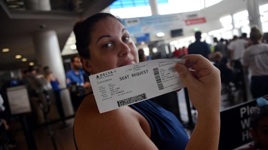 Thousands of Puerto Ricans are headed to the mainland to sit our the destruction in the island. Here a woman holds a ticket to Miami at Luis Munoz Marin International Airport in San Juan.