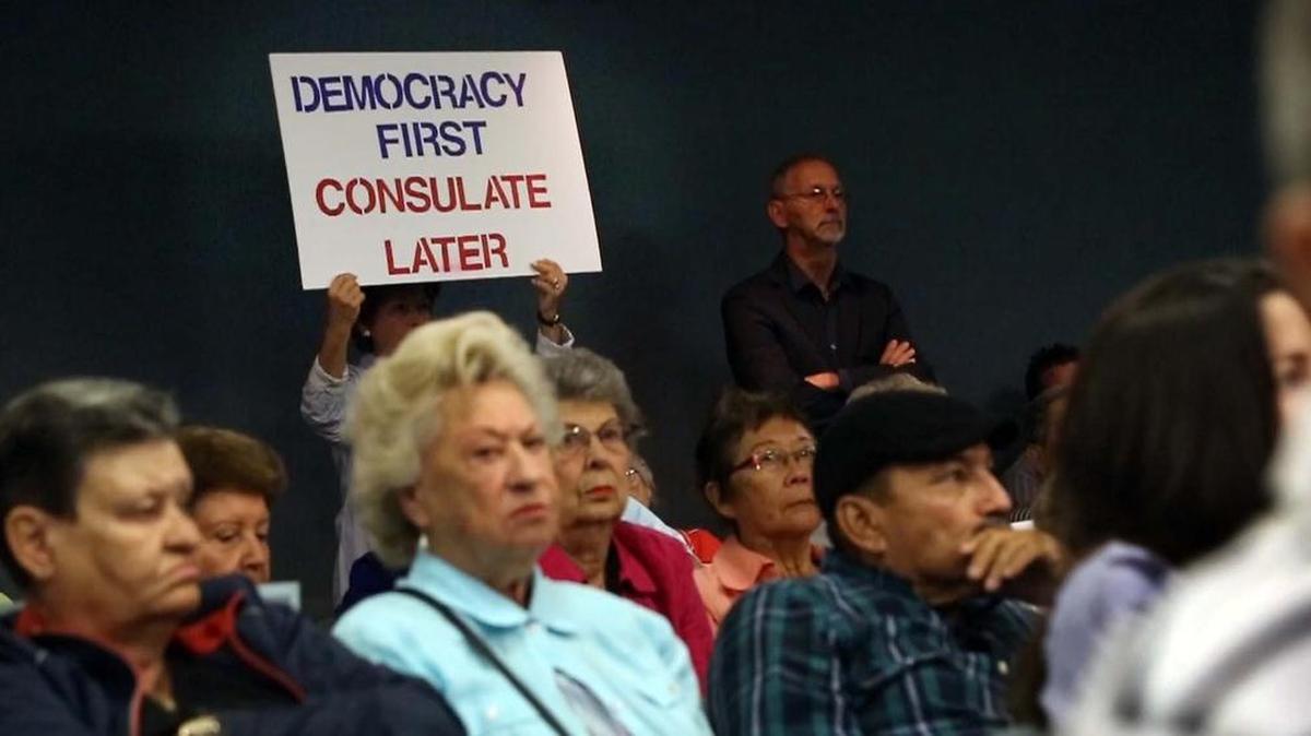 A protestor against locating a Cuban consulate in Miami Beach lets her feelings be known at a commission meeting this week.