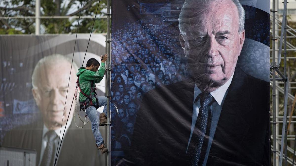 An Israeli worker in Tel Aviv hangs up a billboard with a portrait of late Israeli Prime Minister Yitzhak Rabin, ahead of a memorial rally for the 20th anniversary of his assassination.