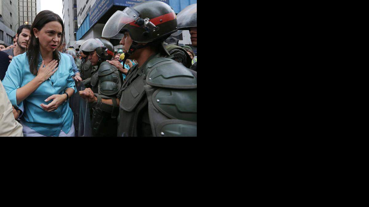
ACCUSED: Opposition leader Maria Corina Machado speaks to National Guard soldiers as she arrives to testify at a prosecutor’s office last week. 
