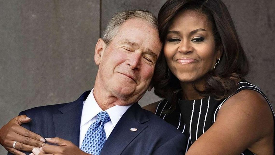 Former President George W. Bush gets a hug from then-first lady Michelle Obama at the opening of the Smithsonian National Museum of African American History and Culture in Washington, D.C.