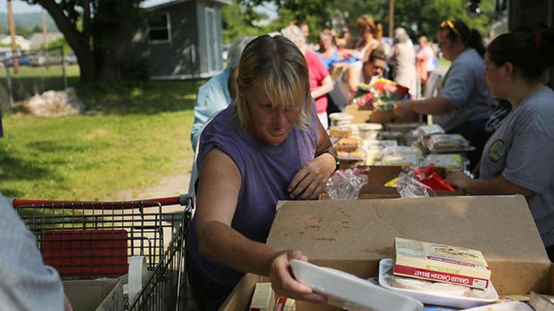 In 2012, people looked through boxes of food during a distribution event by the Food Bank of the Southern Tier Mobile Food Pantry in Oswego, New York.