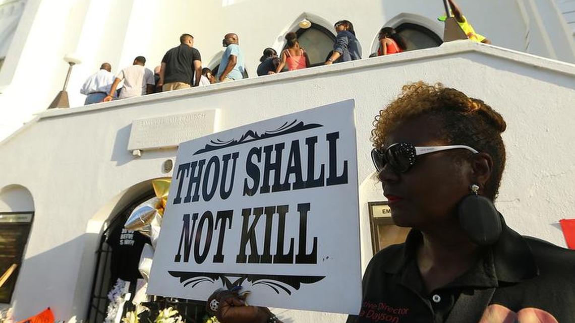
Linda Dayson holds a sign as members of the public and church members enter the "Mother" Emanuel A.M.E. Church for Sunday service four days after the mass shooting that claimed the lives of its pastor and eight others on Sunday, June 21, 2015, in Charleston, S.C. 
