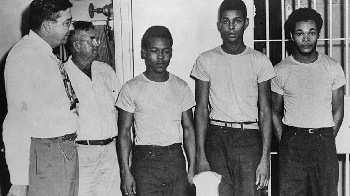 Sheriff and jailer stand with three suspects, Walter Irvin, Charles Greenlee, and Samuel Shepherd. A fourth suspect had been killed.