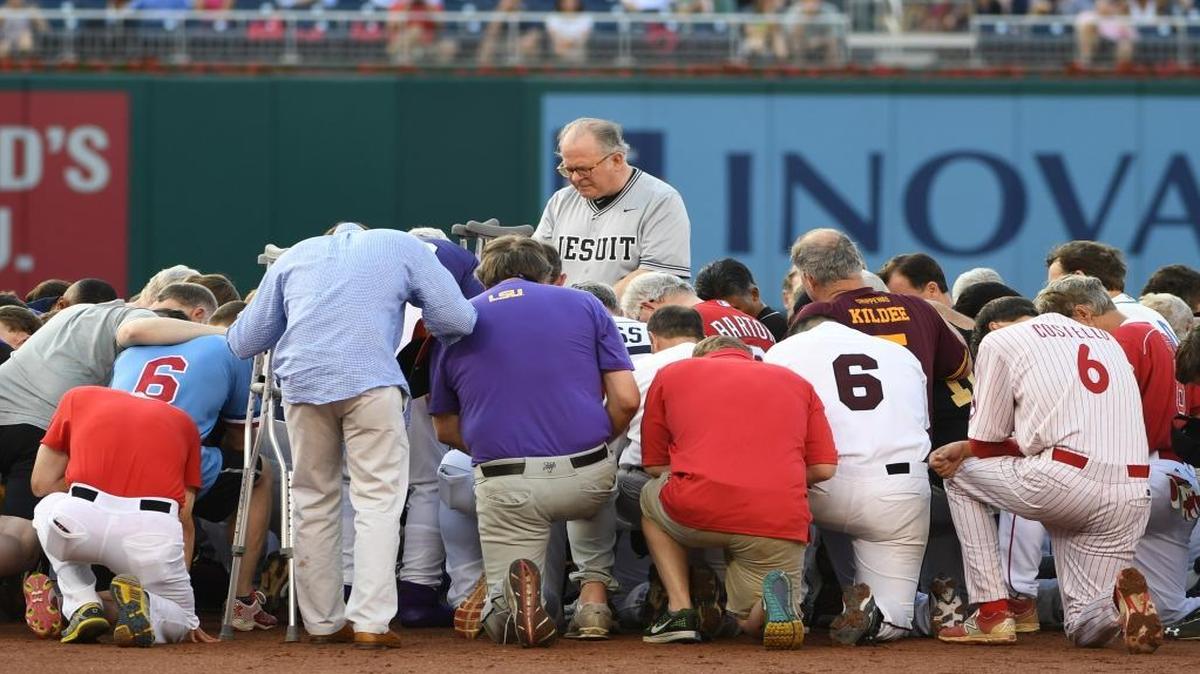 The House chaplain leads Democrats and Republicans in prayer at second base before the Congressional Baseball Game on Thursday evening at Nationals Park in Washington.