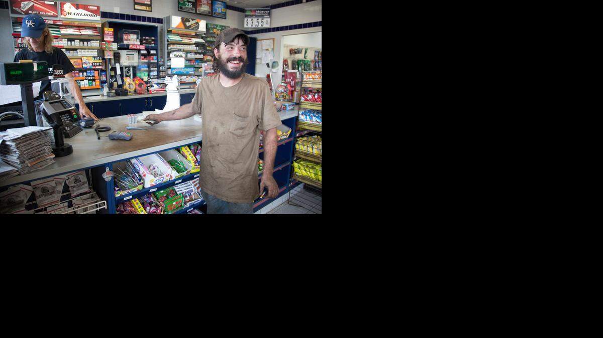 
Samuel Riley, right, stops at the Valero gas station after getting off work as a mechanic to buy some cigarettes from Roger Baker in Booneville, Ky. Wednesday August 6, 2014. Booneville and Owsley County are statistically one of the poorest in the country, but many of it's residents find it a good place to live unless you are young and looking for a job. 
