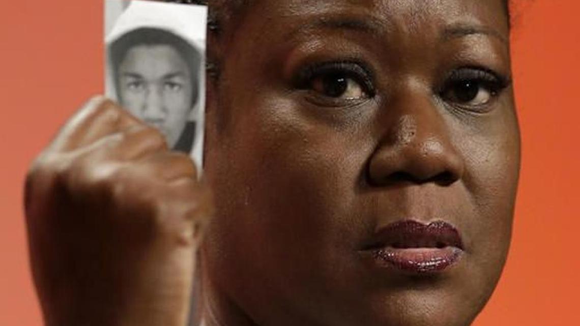 Sybrina Fulton, mother of Trayvon Martin, holds up a card with a photo of her son as she speaks at the National Urban League's annual conference in Philadelphia in 2013.