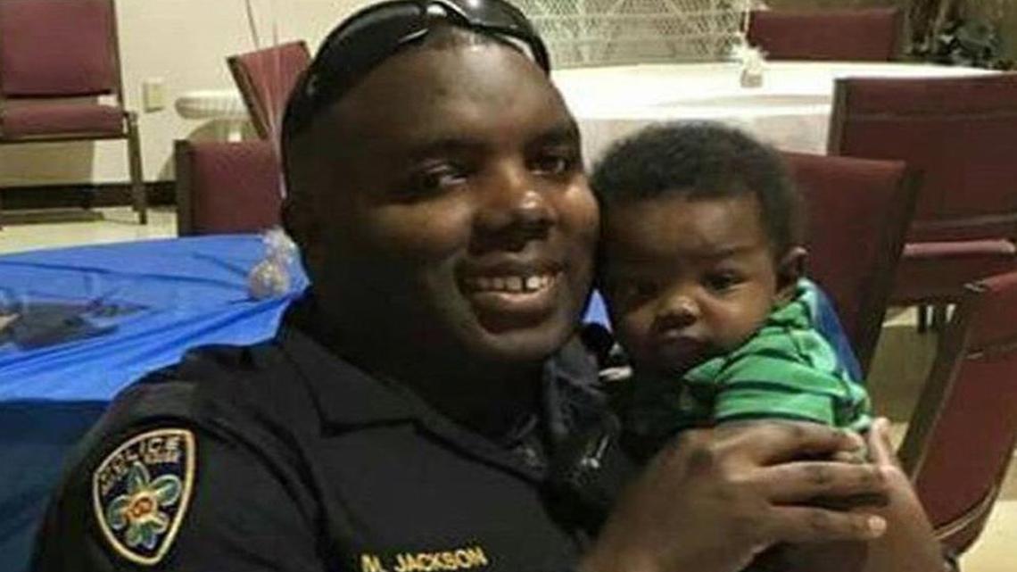 Montrell Jackson, holds his son, Mason, at a Father’s Day event for police officers in Baton Rouge, Louisiana.