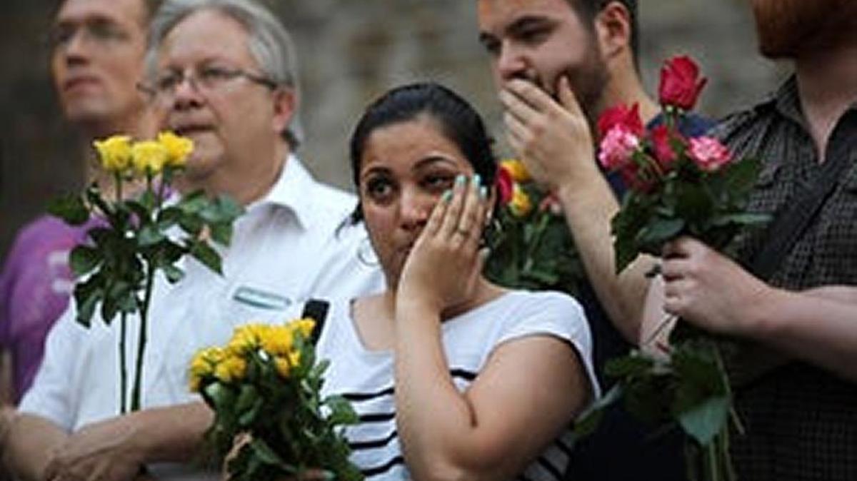 A woman stands with others outside a Finsbury Park mosque where a man drove a truck into a crowd of worshippers.