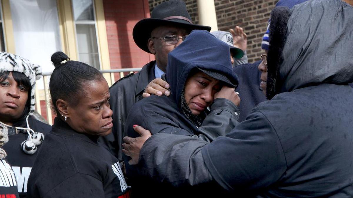 Janet Cooksey, center, the mother of Quintonio LeGrier, is comforted by family and friends after speaking about about the shooting death of her son by the Chicago police.