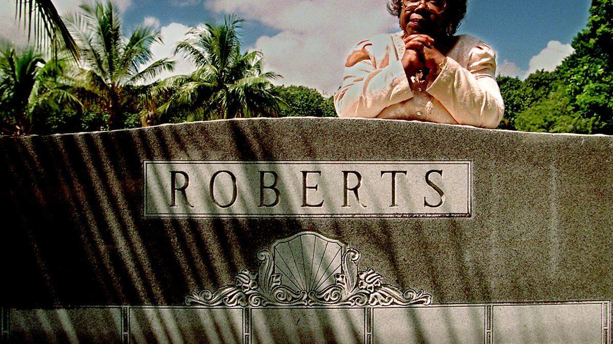 Enid Pinkney stands at Miami City Cemetery which she worked hard to preserve and revitalize in 1999. She is standing by one of the grave markers in the black section of the cemetery.