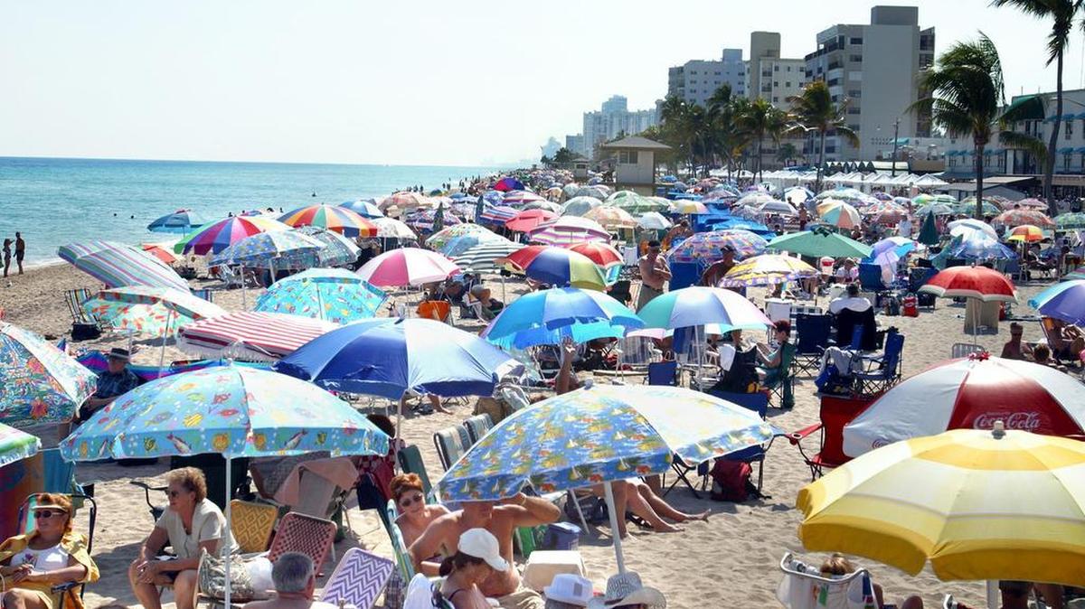 Sunbathers and snowbirds pack Hollywood Beach in 2003. For more than 50 years, French-speaking Canadians from Quebec have flocked to the region each winter.