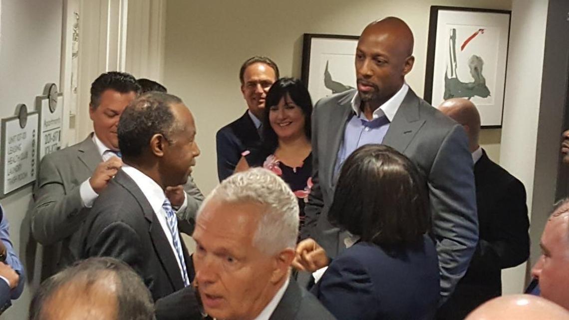 Housing and Urban Development Secretary Ben Carson emerges from a stuck elevator at Courtside Morning Apartments on Wednesday as former NBA pro Alonzo Mourning looks on.