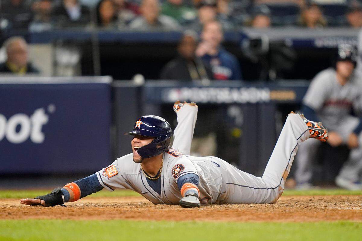 Houston Astros’ Yuli Gurriel reacts as he slides home safely to score against the New York Yankees during the sixth inning of Game 3 of an American League Championship baseball series, Saturday, Oct. 22, 2022, in New York.