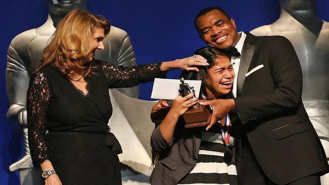 Carmen Sandino of American Senior High School is congratulated by Miami Herald Publisher and President Alexandra Villoch and Miami Herald World Editor John Yearwood after winning the 2015 Silver Knight award for English and Literature on May 20, 2015 at the James L. Knight Center in Downtown Miami.