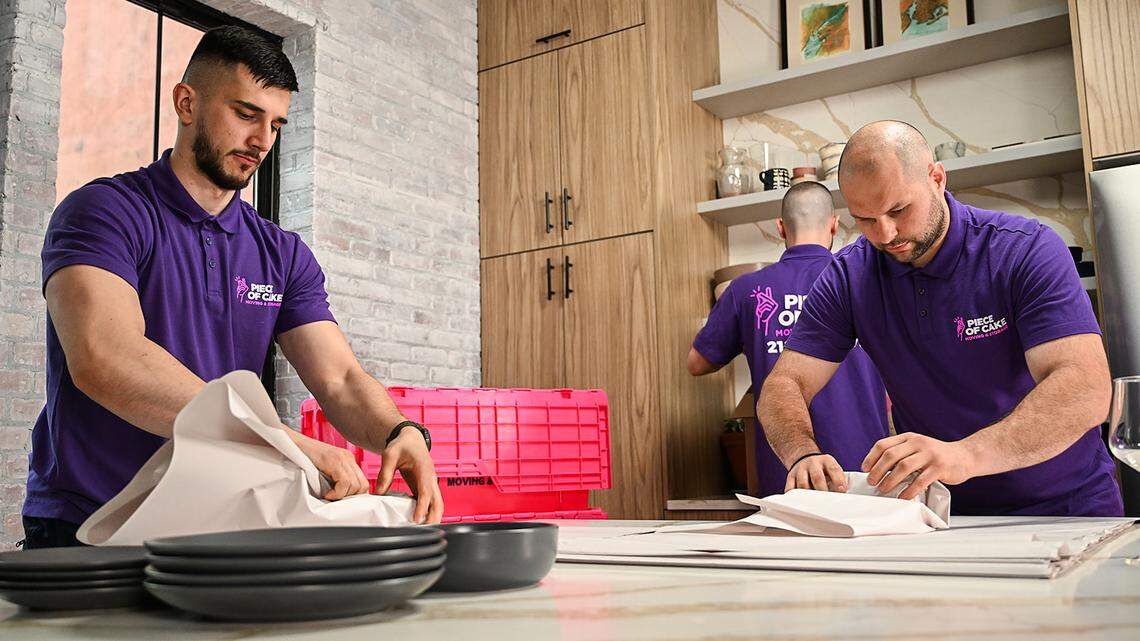 Movers carefully packing kitchen items Piece of Cake Moving.