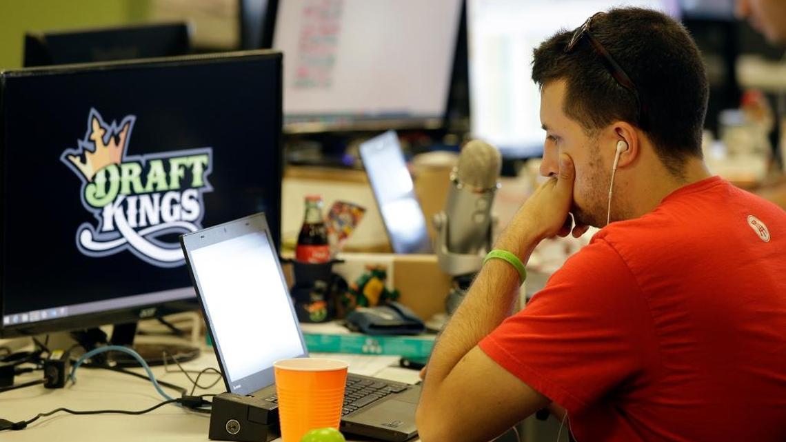 In this Sept. 9, 2015 file photo, Devlin D'Zmura, a tending news manager at DraftKings, a daily fantasy sports company, works on his laptop at the company's offices in Boston. DraftKings, along with another company FanDuel, now face a suit filed by two South Florida player arguing that the sites give high-rolling elite players an edge.