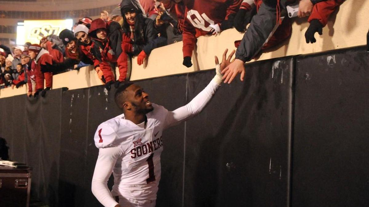 Oklahoma wide receiver Jarvis Baxter celebrates with fans following a game against Oklahoma State in Stillwater, Okla., Saturday, Nov. 28, 2015.