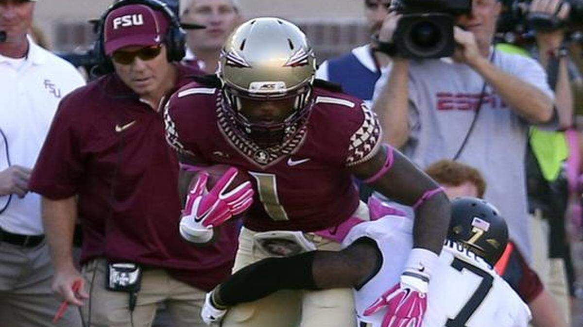 Pushing for more:  FSU coach Jimbo Fisher, left, watches former Homestead wide receiver Ermon Lane get tackled by Wake Forest's Merrill Noel after picking up a first down during Saturday’s game.