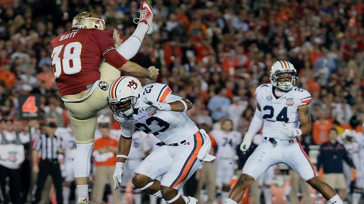
Florida State Seminoles punter Cason Beatty is run into by Auburn Tigers rusher Johnathan Ford for a penalty to extend a Seminoles drive in the first half during the BCS National Championship game at the Rose Bowl in Pasadena, Calif., on Monday, Jan. 6, 2014. 
